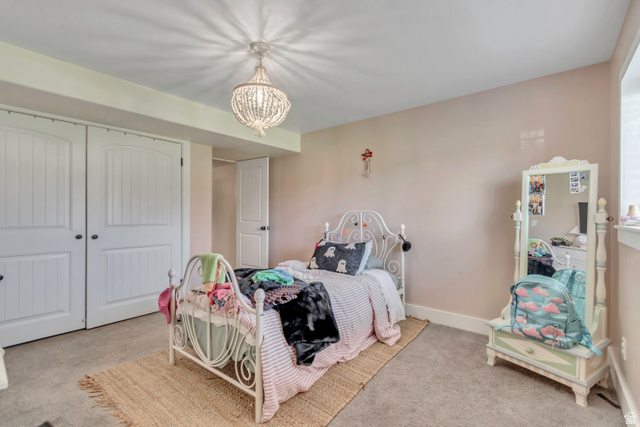 1071 Jamie-Matt Circle Layton, UT 84041 - Photo 6 of 28 Bedroom with light colored carpet, a closet, and hanging lights