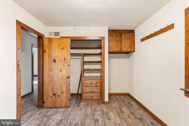 a view of walk in closet with wooden floor