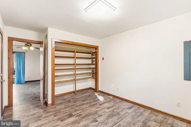 a view of empty room with wooden floor