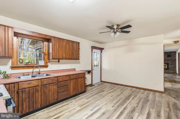 a view of a kitchen with a sink and dishwasher with wooden floor