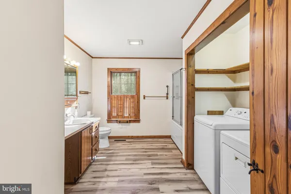 a view of a hallway with wooden floor and cabinet