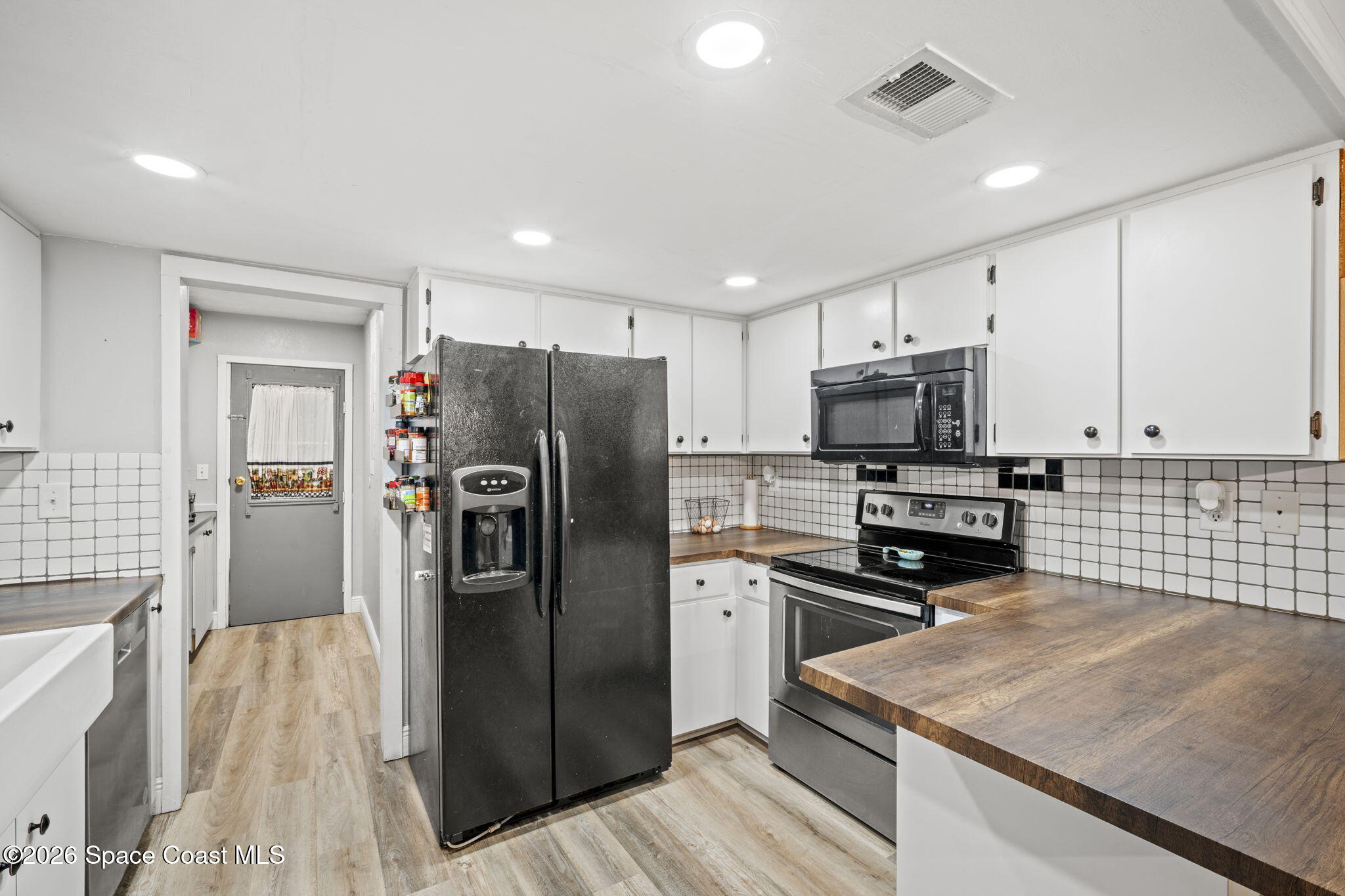 3416 Flounder Creek Road Mims, FL 32754 - Photo 16 of 42 a kitchen with a refrigerator a sink and wooden cabinets