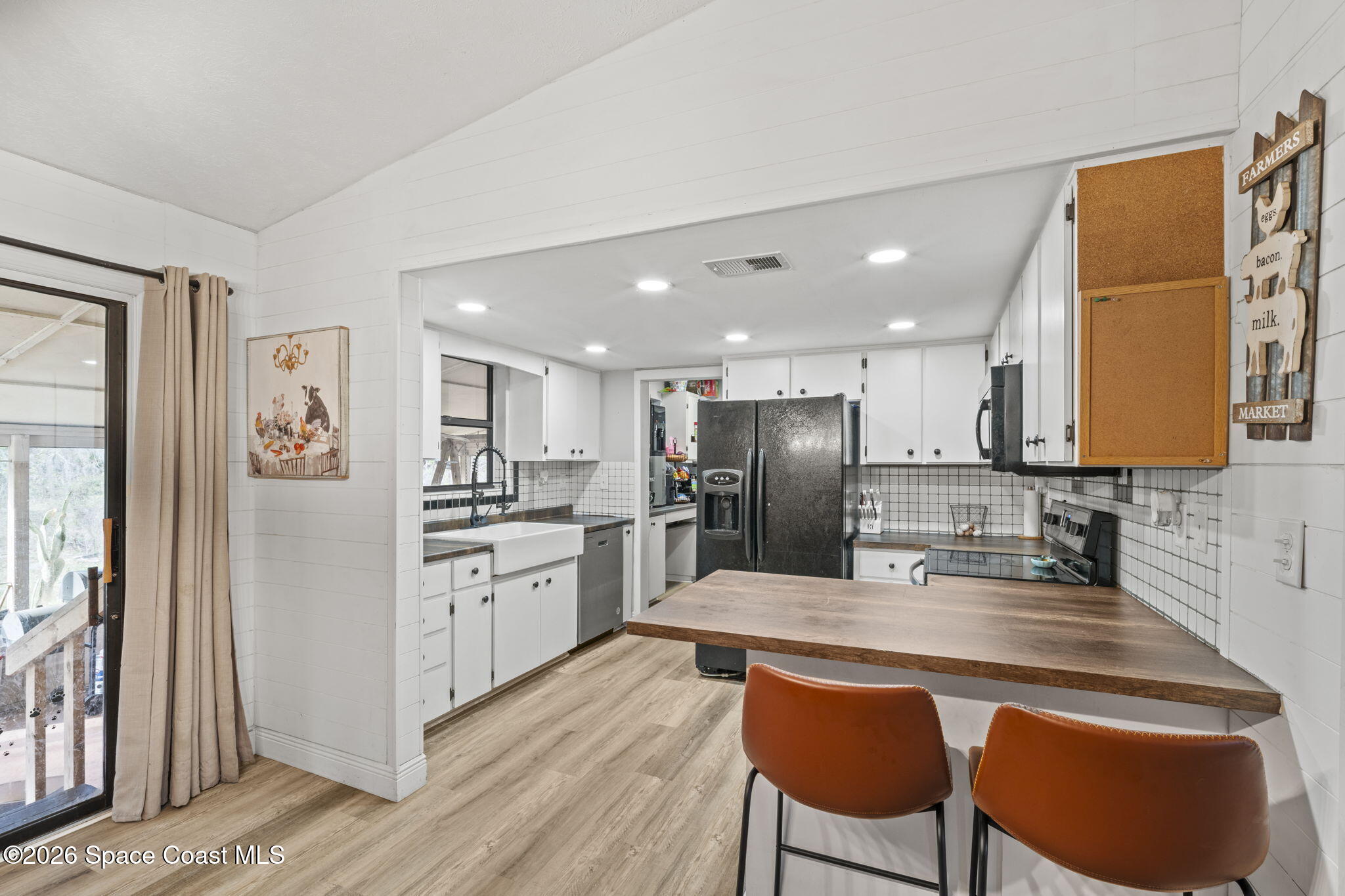 3416 Flounder Creek Road Mims, FL 32754 - Photo 18 of 42 a kitchen with refrigerator cabinets and dining table
