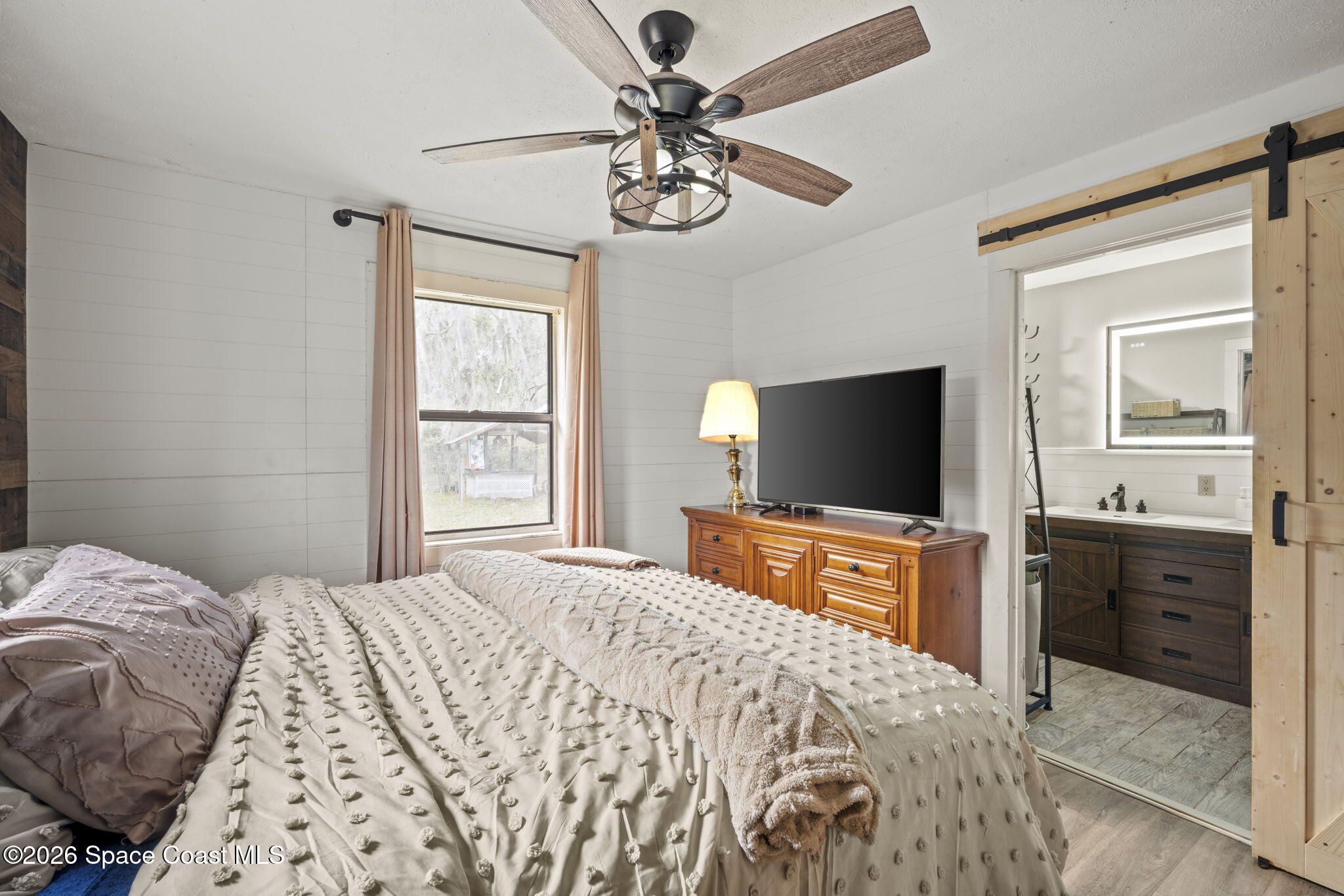 3416 Flounder Creek Road Mims, FL 32754 - Photo 22 of 42 a bedroom with a bed and a flat screen tv