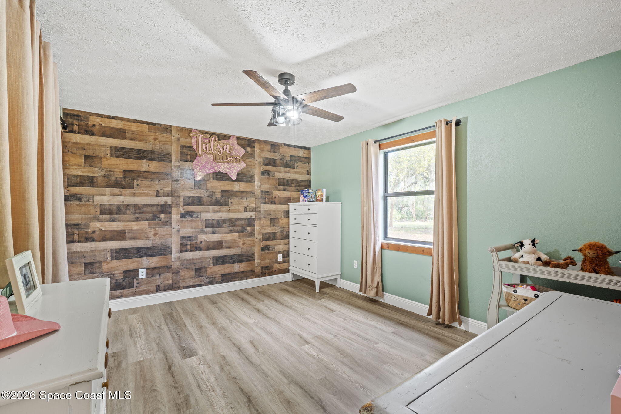 3416 Flounder Creek Road Mims, FL 32754 - Photo 24 of 42 a view of empty room with wooden floor and fan