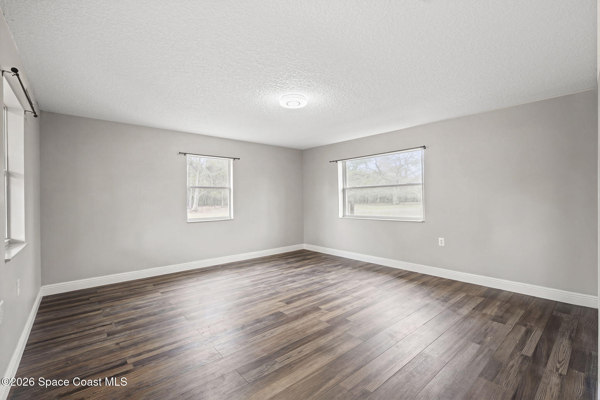 3416 Flounder Creek Road Mims, FL 32754 - Photo 33 of 42 an empty room with wooden floor and windows