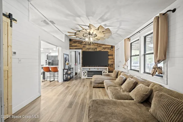 a living room with furniture large window and flat screen tv