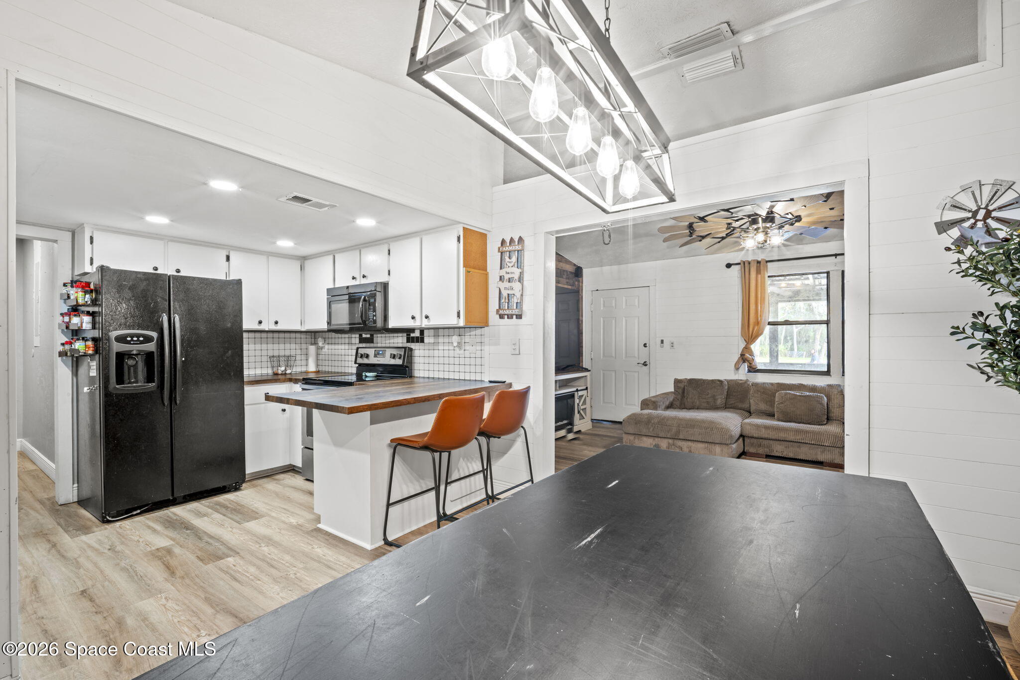 3416 Flounder Creek Road Mims, FL 32754 - Photo 10 of 42 a kitchen with stainless steel appliances kitchen island granite countertop a refrigerator and a stove top oven