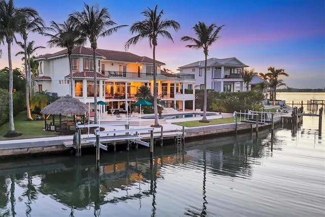 a front view of a house with a yard and potted plants