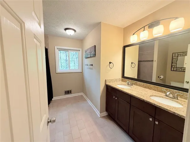 a spacious bathroom with a granite countertop sink mirror and a