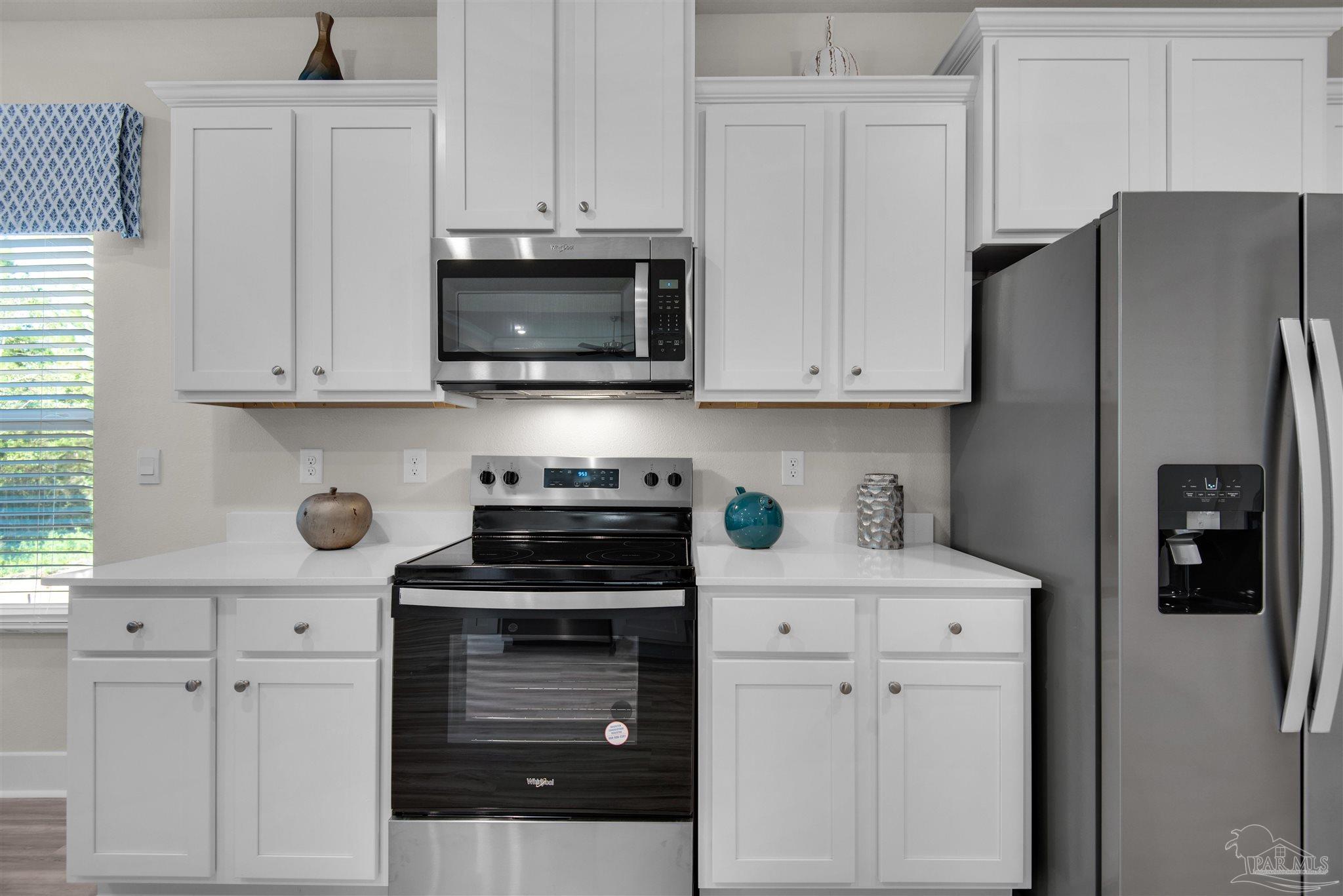 3411 Crossvine Road Cantonment, FL 32533 - Photo 26 of 45 a kitchen with stainless steel appliances granite countertop a refrigerator stove and white cabinets