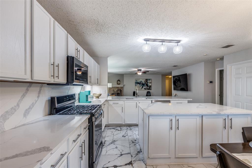 1425 Ridgecrest Drive Little Elm, TX 75068 - Photo 14 of 27 a kitchen with stainless steel appliances granite countertop a sink stove and cabinets