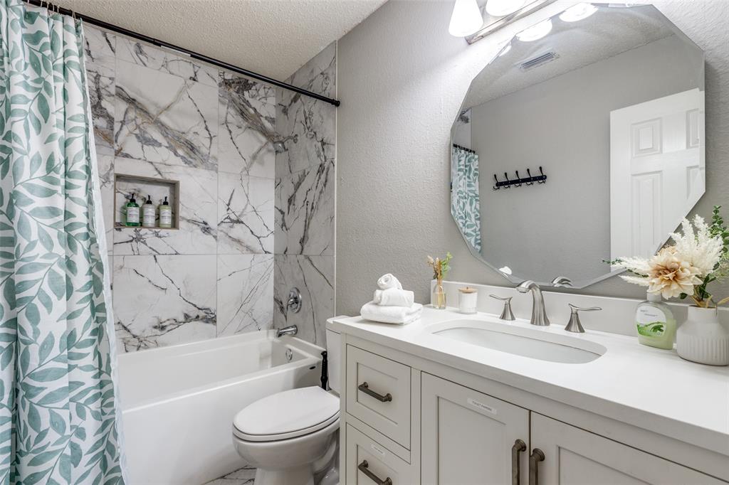 1425 Ridgecrest Drive Little Elm, TX 75068 - Photo 22 of 27 a bathroom with a sink a toilet and a large mirror