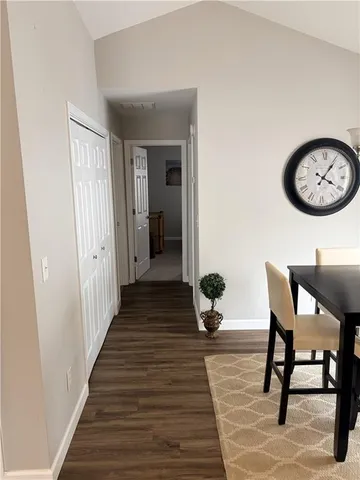a view of a hallway with wooden floor and furniture