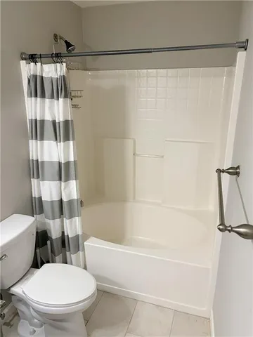 a bathroom with a granite countertop toilet sink and mirror