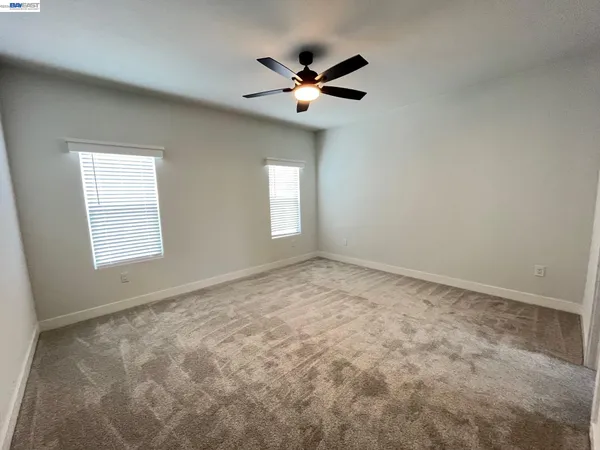 a view of a livingroom with a ceiling fan and window