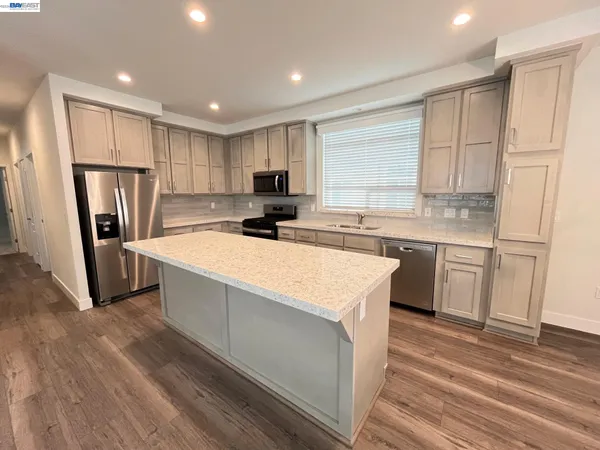 a kitchen with refrigerator cabinets and wooden floor