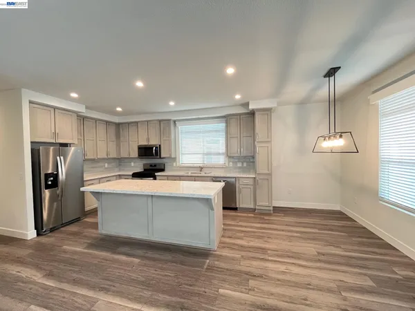 a kitchen with kitchen island a sink and a refrigerator