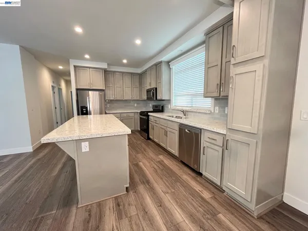 a kitchen with a sink a refrigerator and cabinets