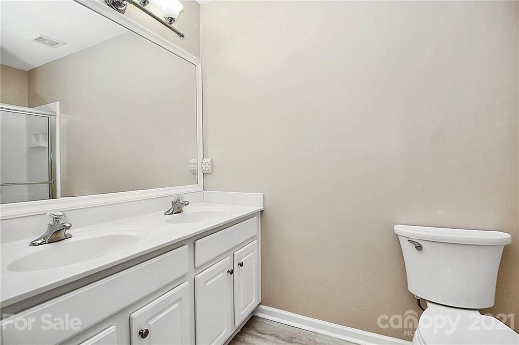 16844 Timber Crossing Road, Unit 2111 Charlotte, NC 28213 - Photo 13 of 33 a bathroom with a toilet a sink and mirror
