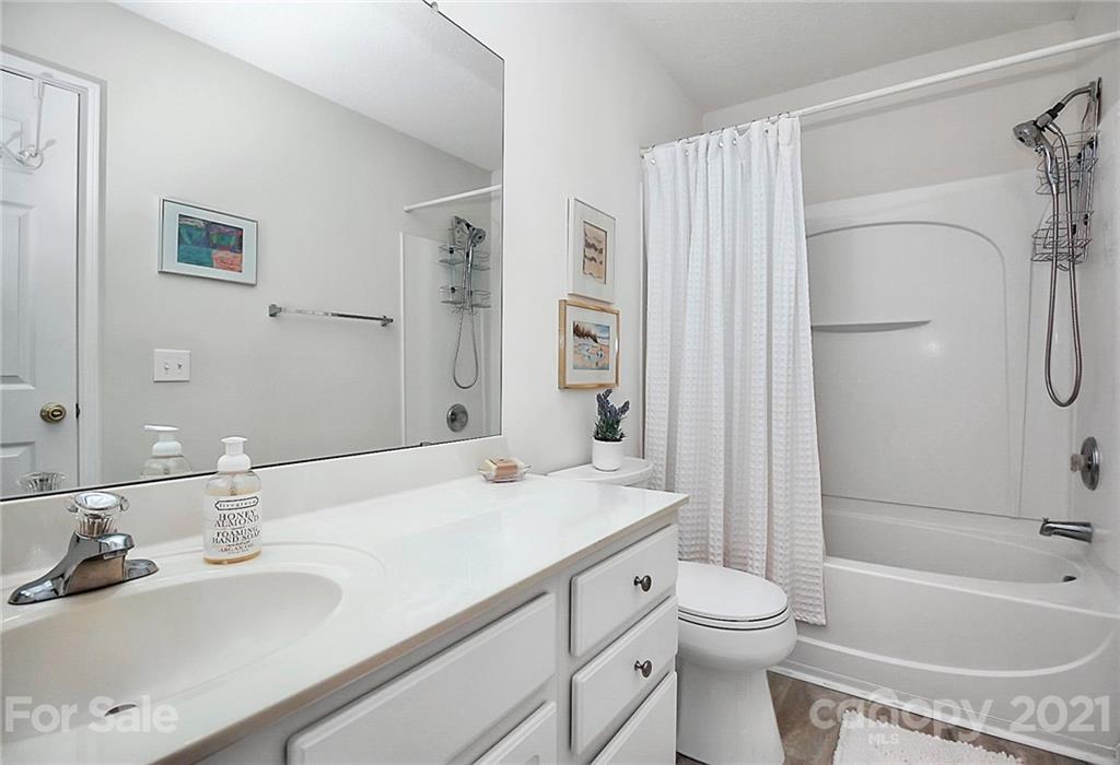 16844 Timber Crossing Road, Unit 2111 Charlotte, NC 28213 - Photo 20 of 33 a bathroom with a granite countertop sink toilet and shower