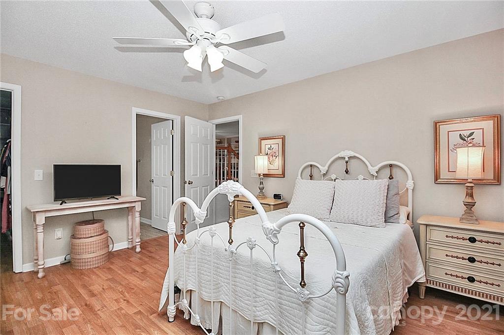 16844 Timber Crossing Road, Unit 2111 Charlotte, NC 28213 - Photo 24 of 33 a spacious bedroom with a bed and a flat screen tv