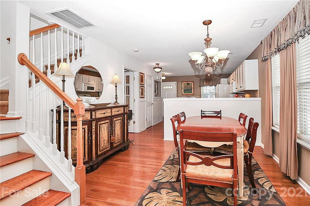 16844 Timber Crossing Road, Unit 2111 Charlotte, NC 28213 - Photo 6 of 33 a view of a dining room with furniture a chandelier and wooden floor