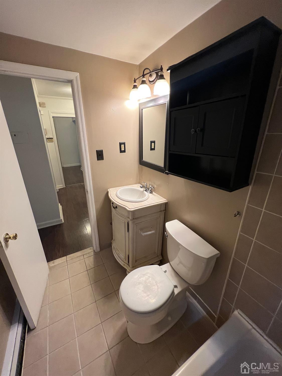 C E Front Street, Unit 95 Plainfield, NJ 07062 - Photo 7 of 14 a bathroom with a toilet a sink and a mirror