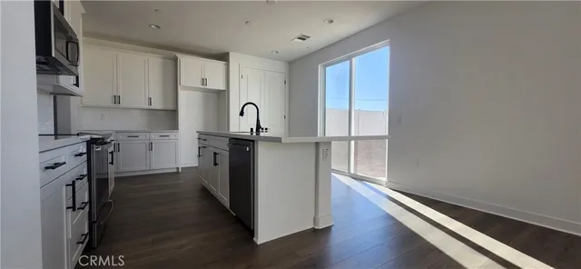 a kitchen with a refrigerator sink and cabinets