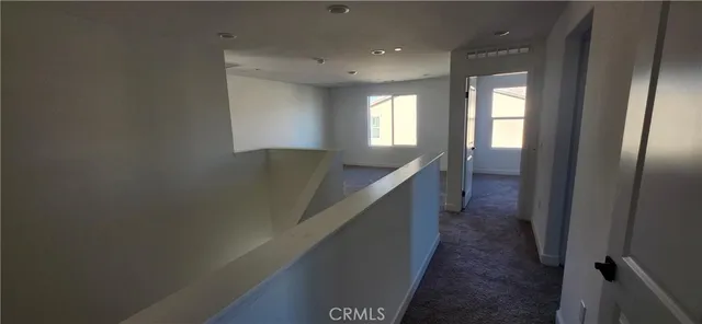 a hallway with windows and chandelier