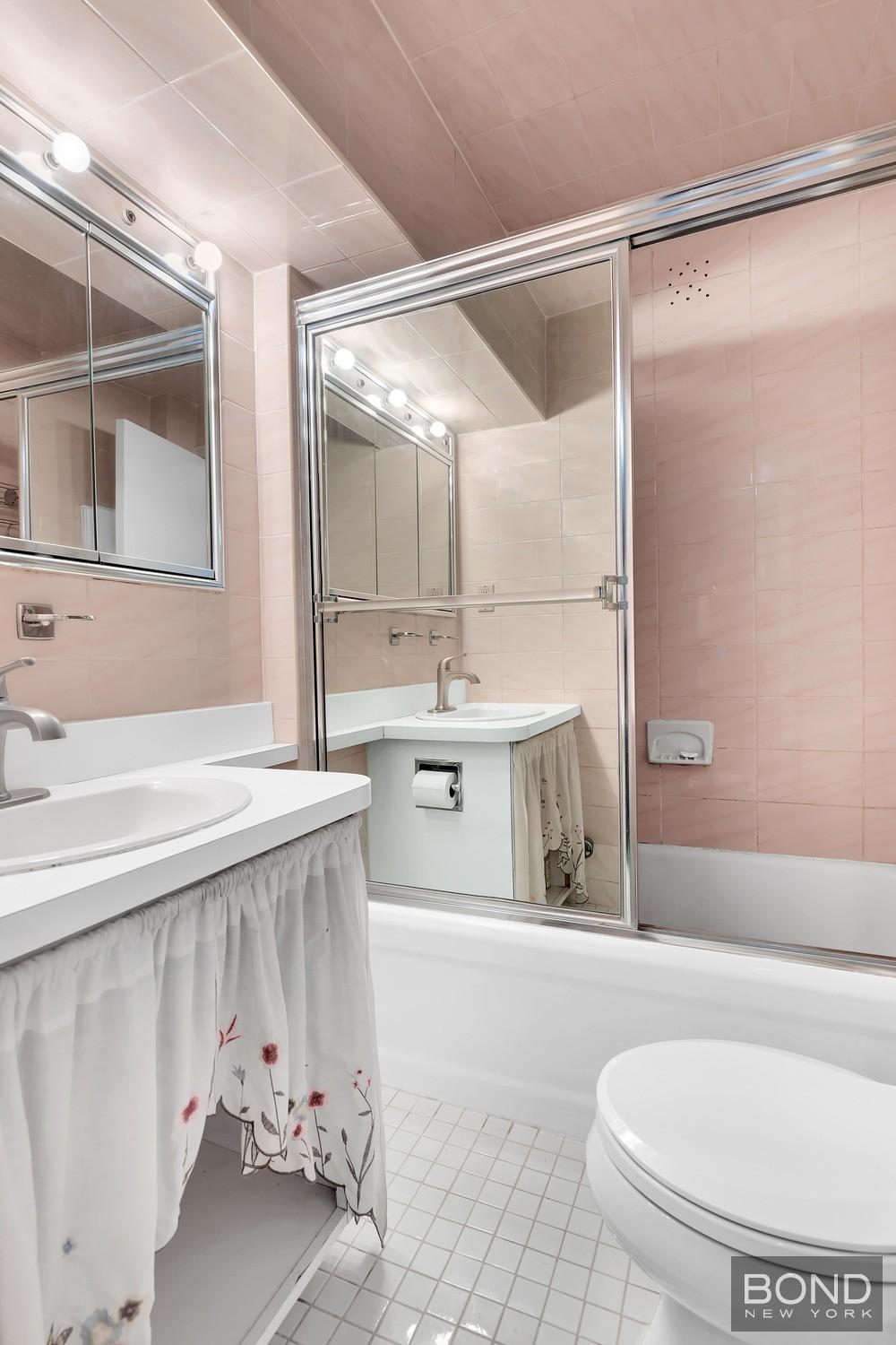 10 Park Avenue, Unit 14H Manhattan, NY 10016 - Photo 5 of 14 a bathroom with a sink and mirror with bathtub