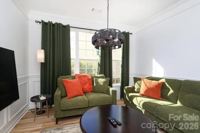 a living room with furniture and a chandelier