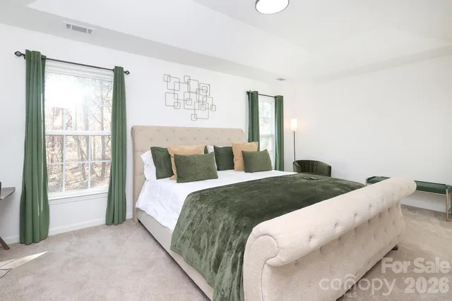 a bed sitting in a bedroom next to a window