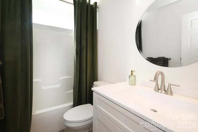 a bedroom with a bed and a flat tv screen on a dresser