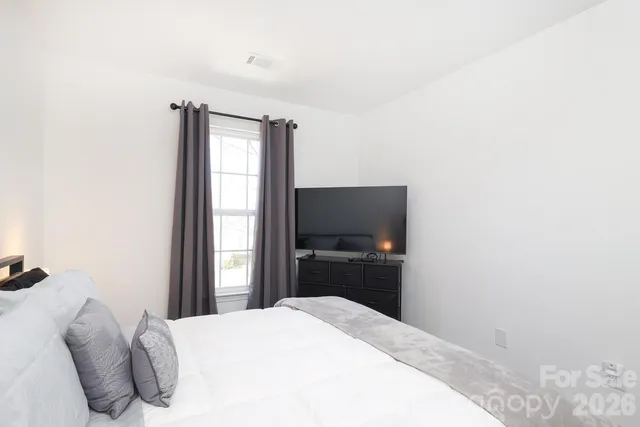 a large bed in a white room