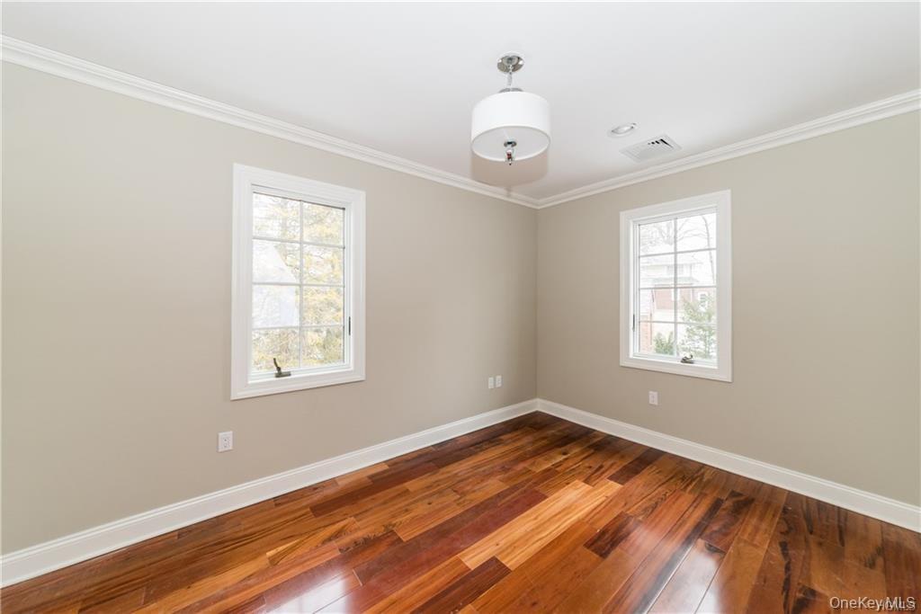 1 Elizabeth Road New Rochelle, NY 10804 - Photo 21 of 23 Unfurnished room with plenty of natural light, baseboards, hardwood / wood-style floors, and crown molding