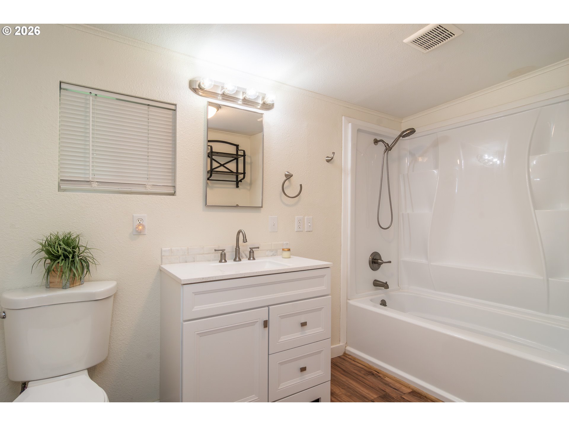 139 South R Street Riddle, OR 97469 - Photo 15 of 33 a bathroom with a sink a toilet a mirror a vanity a bath tub and shower