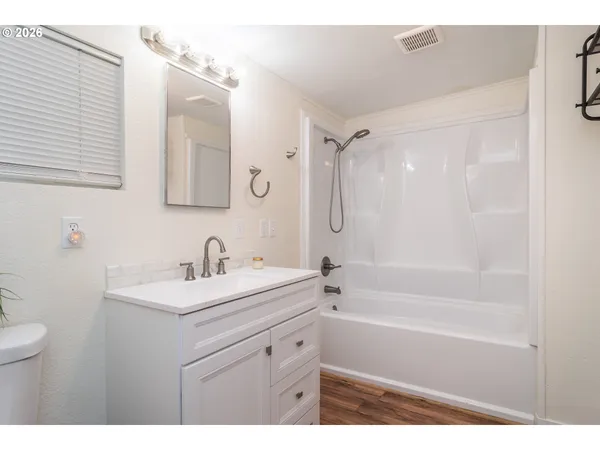 a bathroom with a sink double vanity mirror and a bathtub