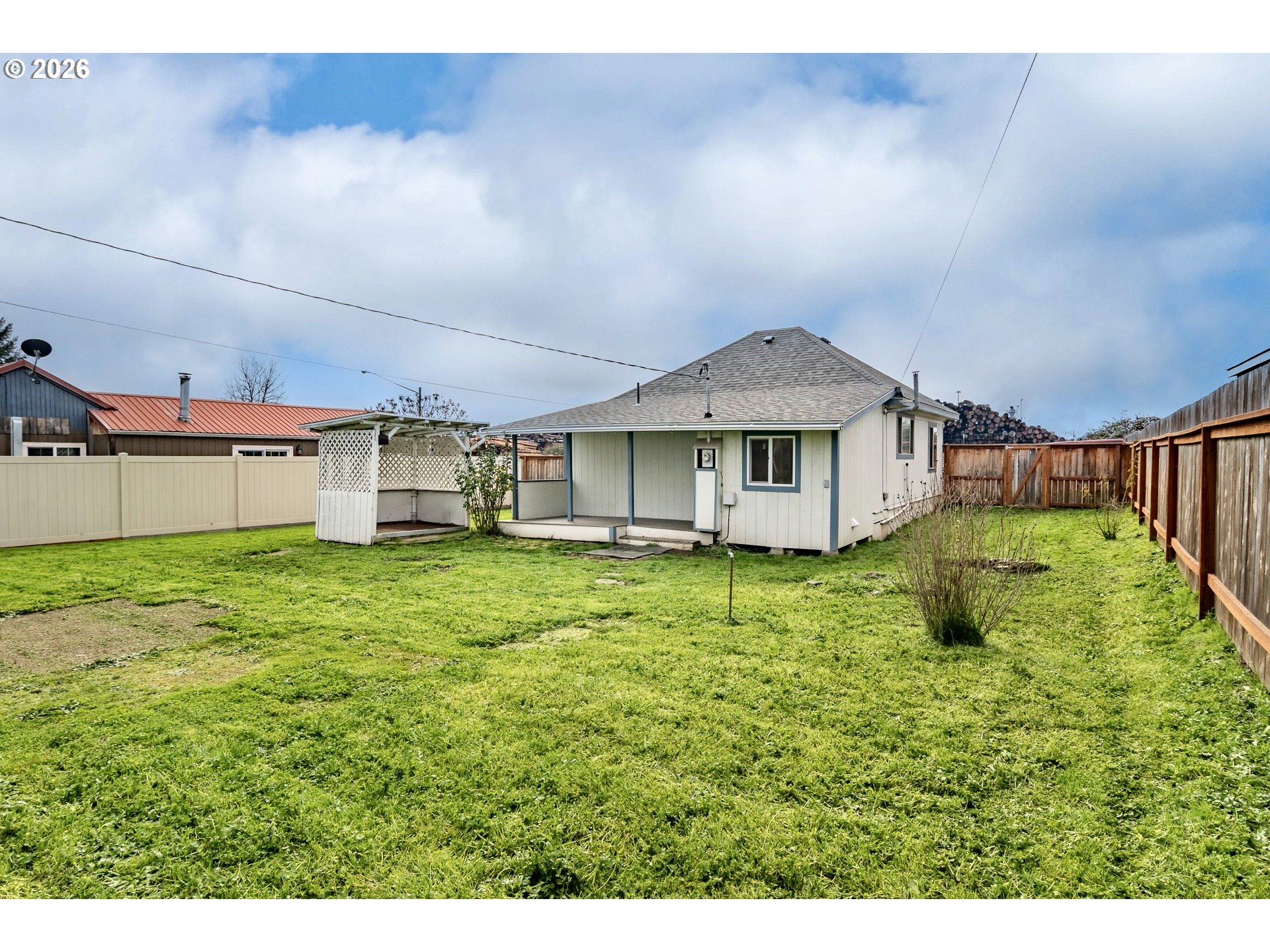 139 South R Street Riddle, OR 97469 - Photo 30 of 33 a yellow house with a big yard and large trees