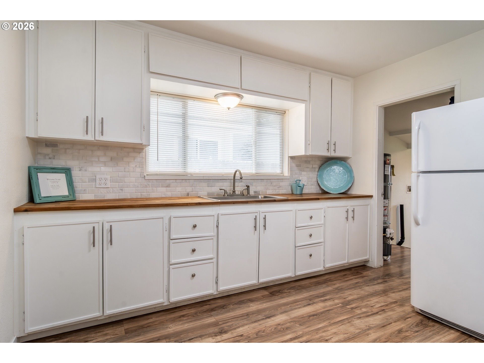 139 South R Street Riddle, OR 97469 - Photo 10 of 33 a kitchen with granite countertop white cabinets white appliances a sink and a window