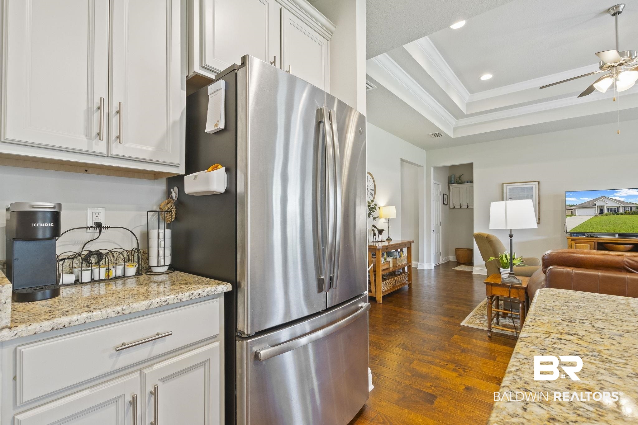 31663 Kestrel Loop Daphne, AL 36527 - Photo 29 of 86 Kitchen featuring stainless steel refrigerator, ceiling fan, dark hardwood / wood-style floors, a tray ceiling, and white cabinets
