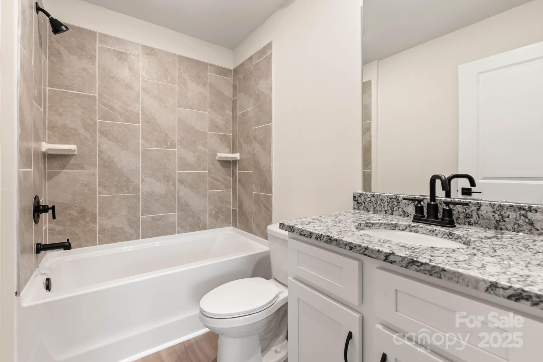 109 Rills Xing Way Troutman, NC 28166 - Photo 19 of 19 a bathroom with a granite countertop sink toilet and bathtub