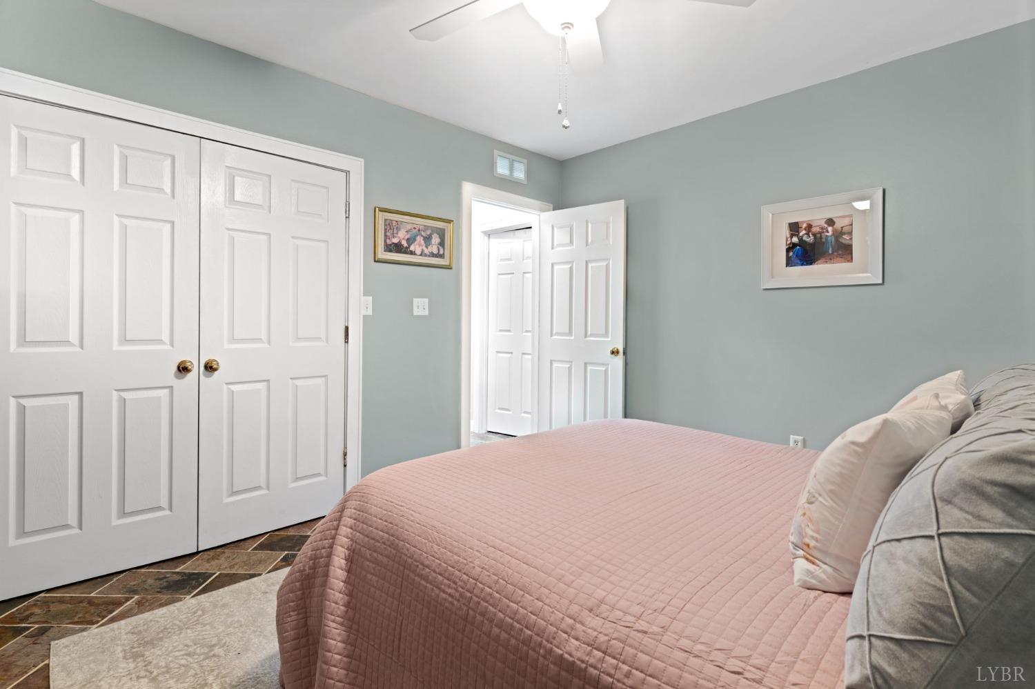 3297 Midway Road Phenix, VA 23959 - Photo 64 of 89 a bedroom with a large bed and a chandelier