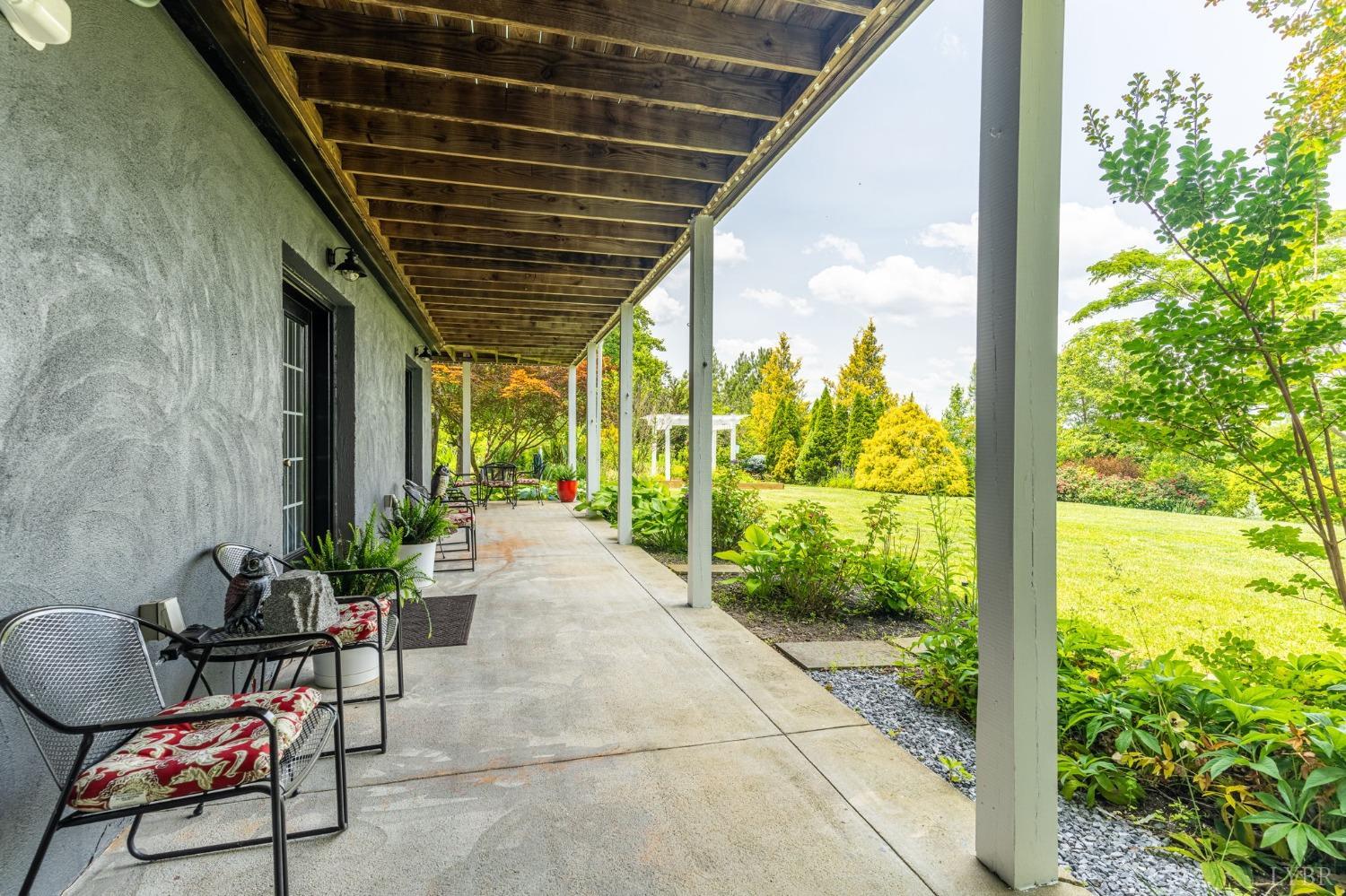 3297 Midway Road Phenix, VA 23959 - Photo 88 of 89 a porch with a table and chairs and potted plants