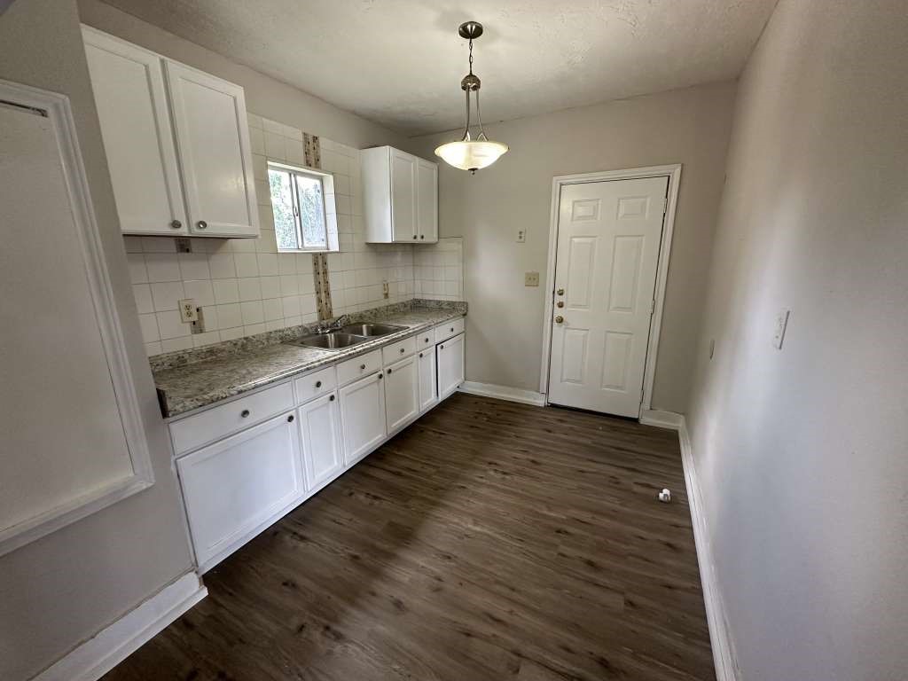 4520 Falls Street Houston, TX 77026 - Photo 6 of 11 a large kitchen with cabinets wooden floor stainless steel appliances and a chandelier