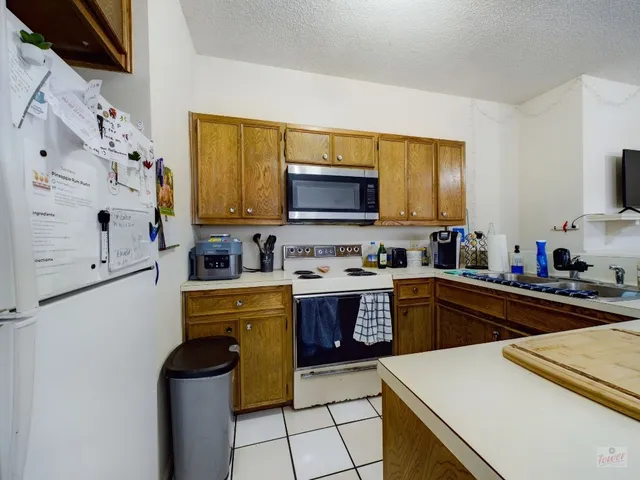 a kitchen with granite countertop a stove top oven microwave and cabinets
