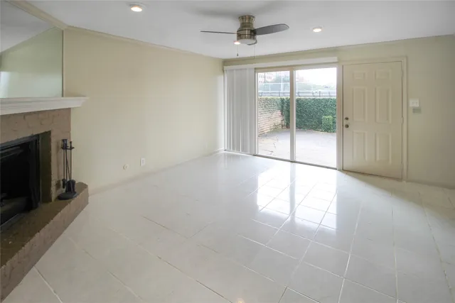 a view of empty room with floor to ceiling window and ceiling fan