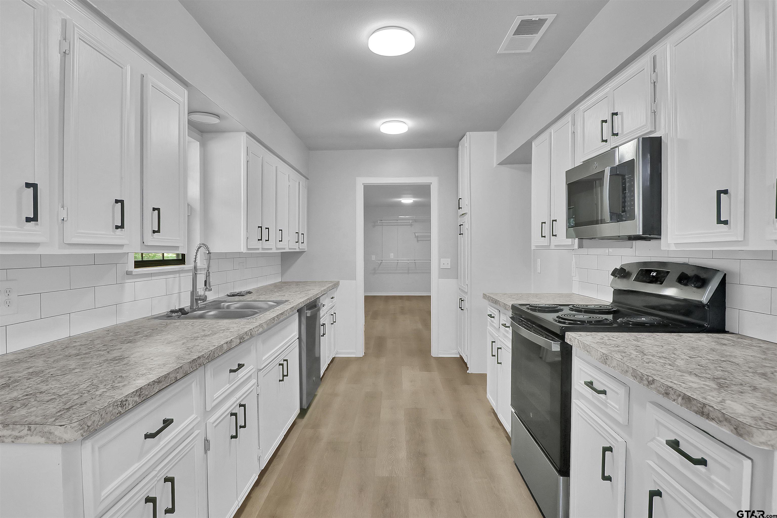 1310 Ridgeview Drive Tyler, TX 75701 - Photo 12 of 30 a large kitchen with stainless steel appliances granite countertop a stove a sink dishwasher and a refrigerator