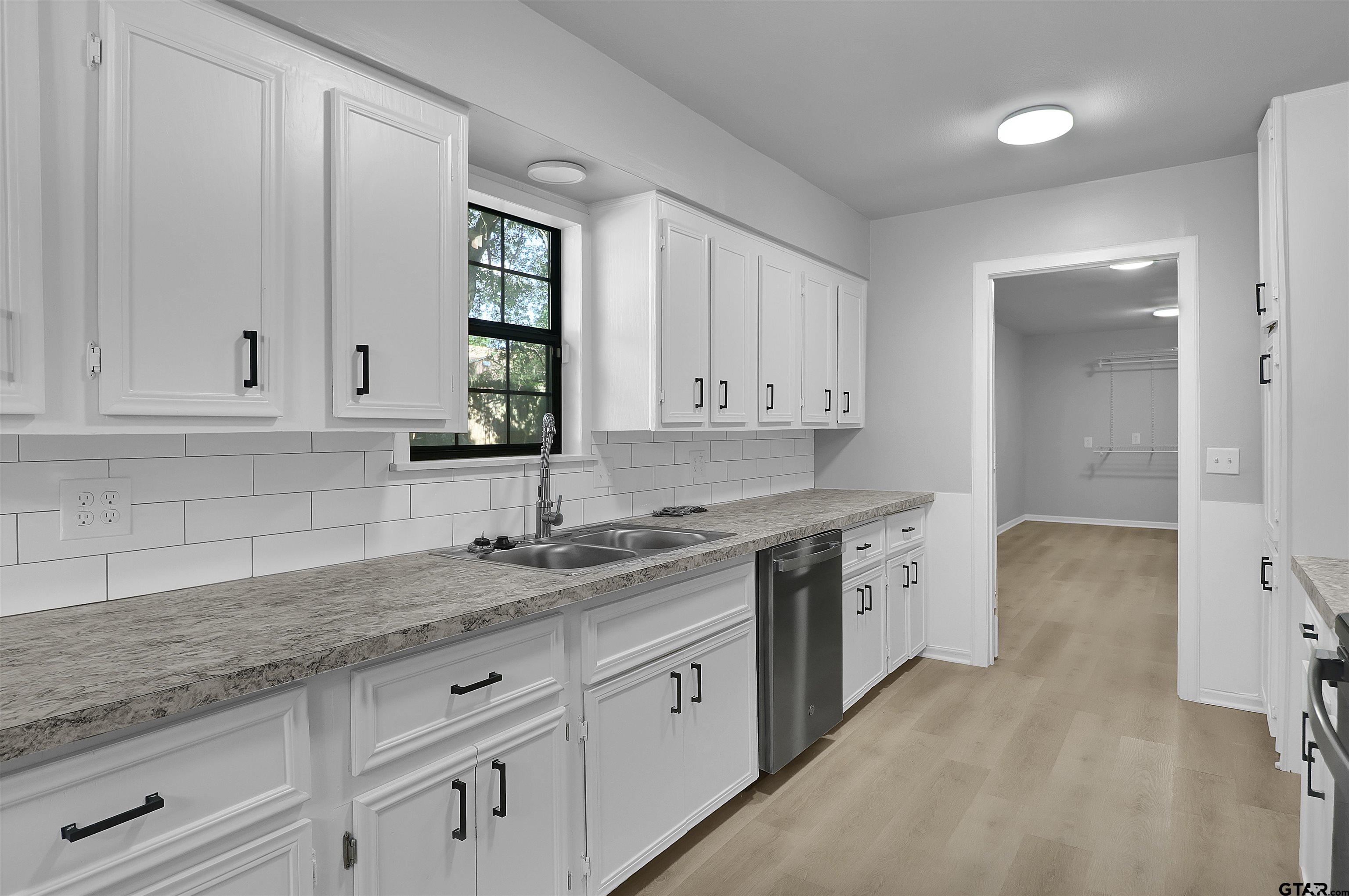 1310 Ridgeview Drive Tyler, TX 75701 - Photo 15 of 30 a kitchen with granite countertop white cabinets and stainless steel appliances