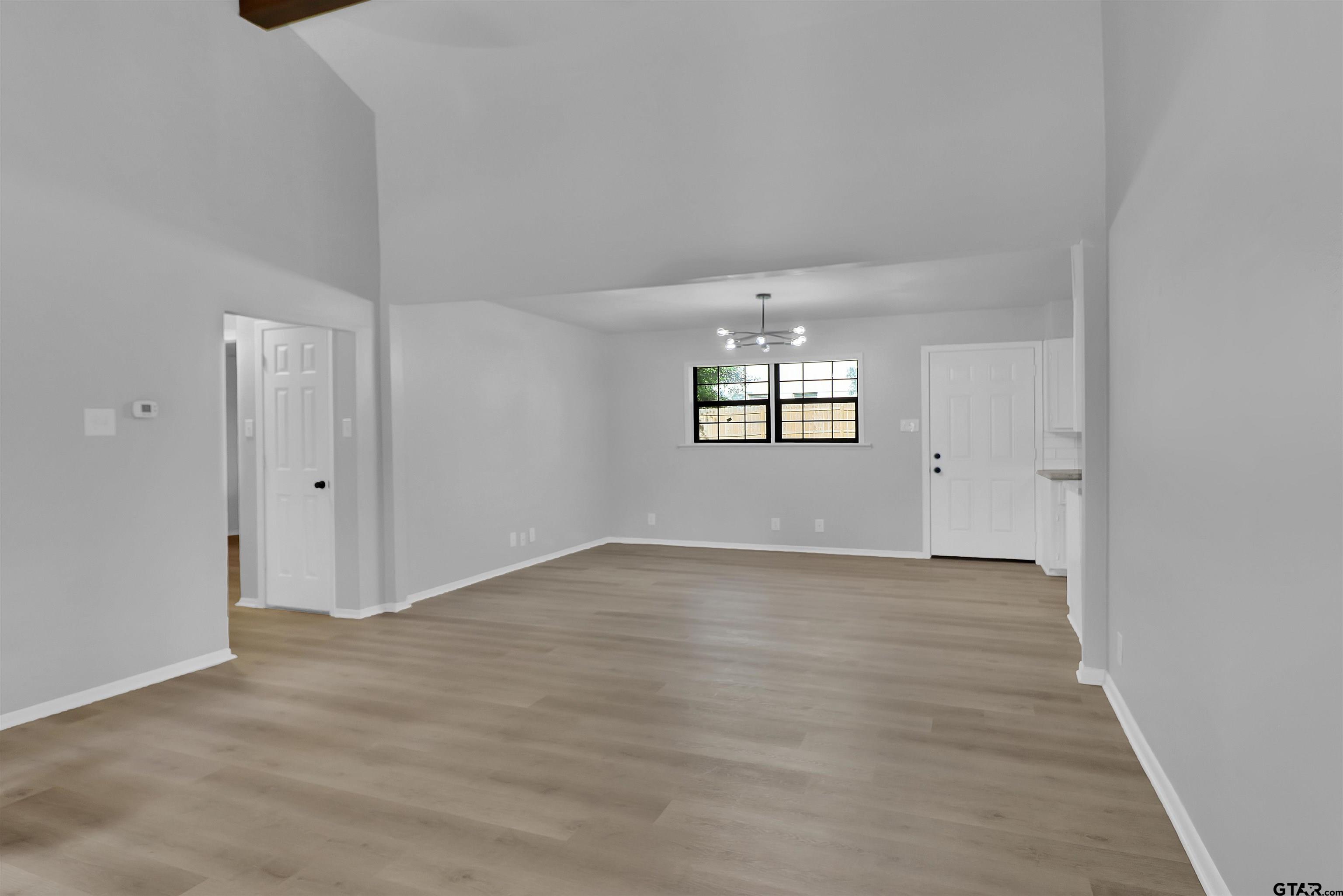 1310 Ridgeview Drive Tyler, TX 75701 - Photo 6 of 30 an empty room with wooden floor and windows